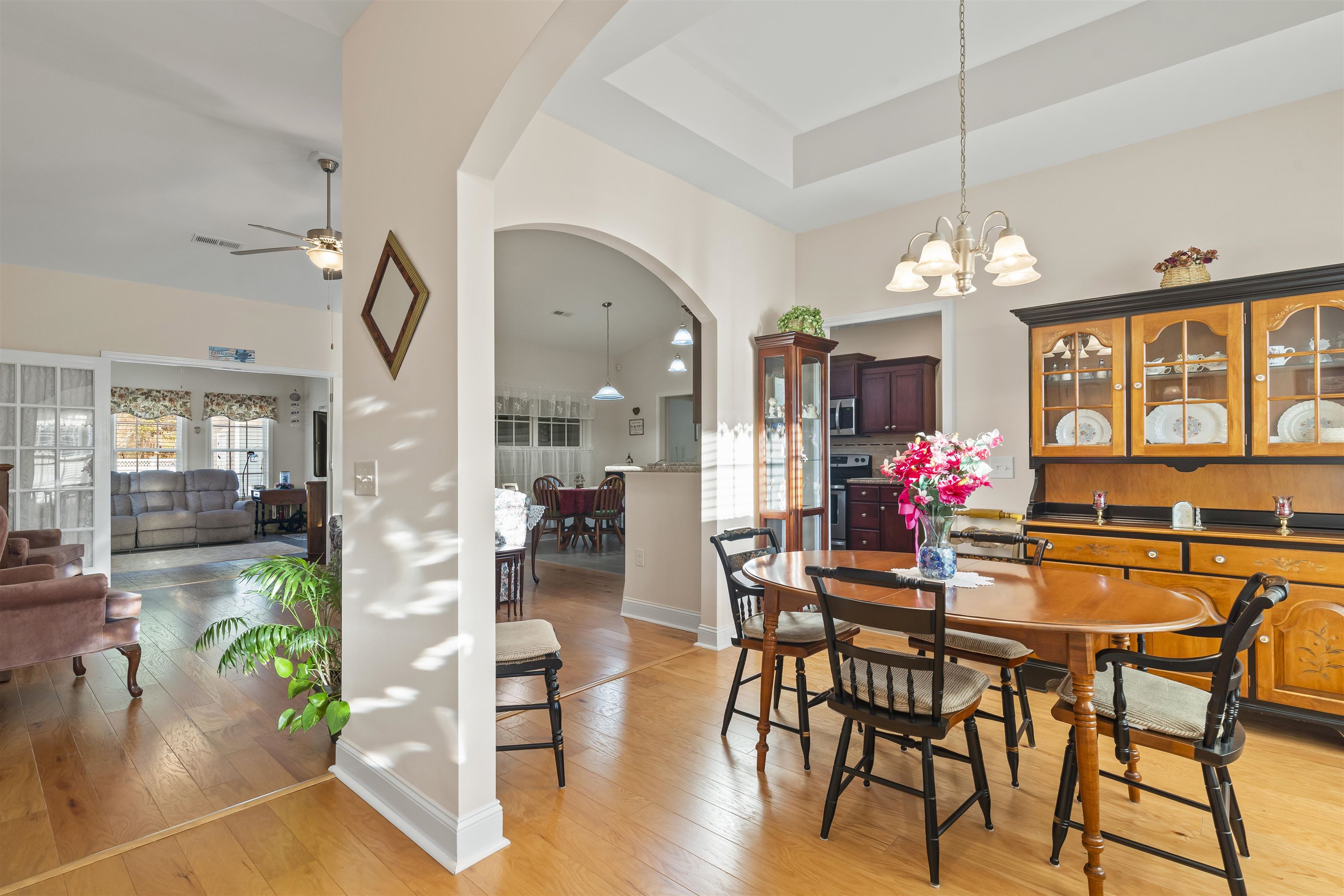 830 Payne Court Conway, SC 29526 - Photo 5 of 38 Dining space with arched walkways, light wood-type flooring, a raised ceiling, and a chandelier
