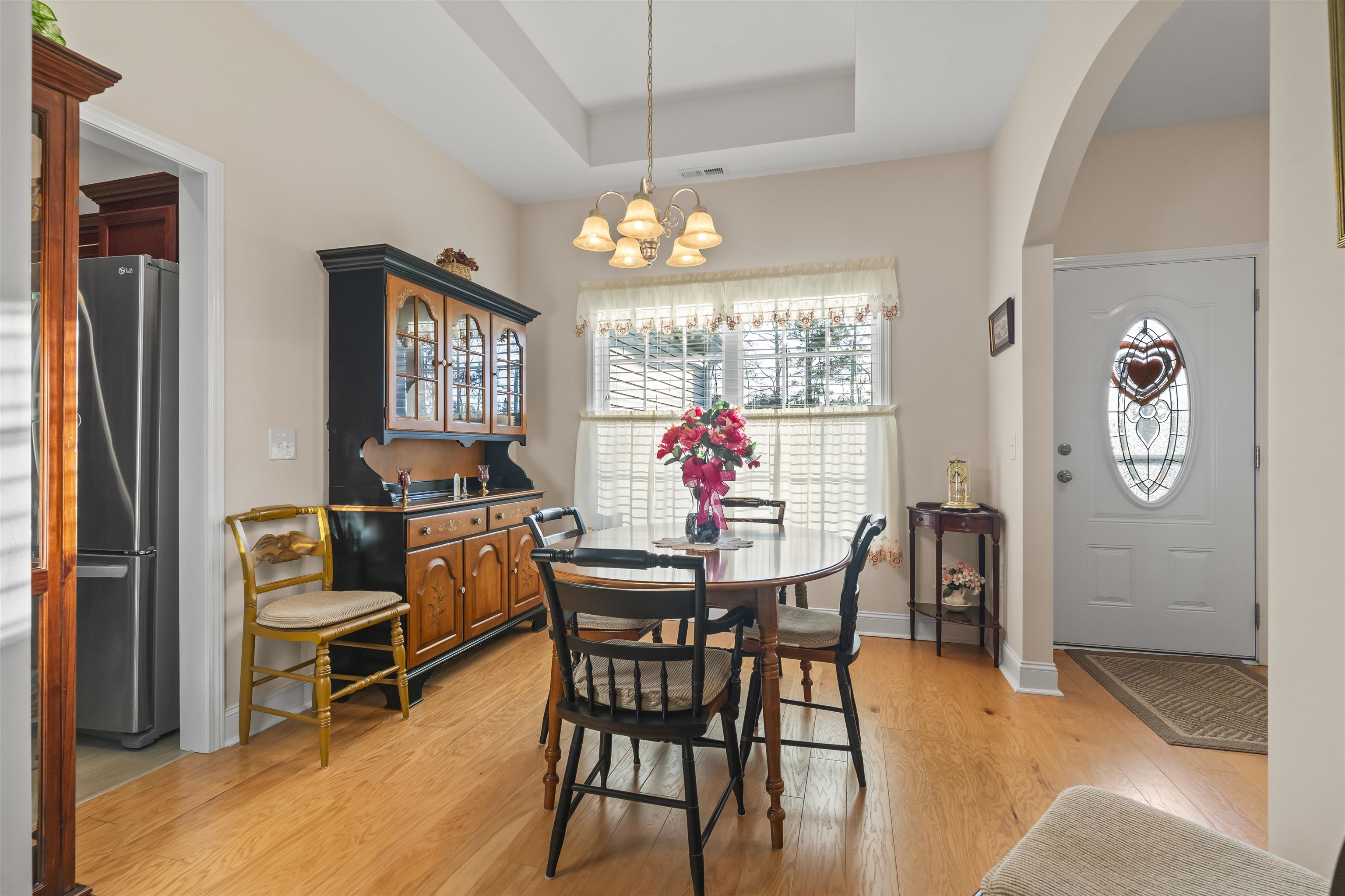 830 Payne Court Conway, SC 29526 - Photo 7 of 38 Dining space featuring a tray ceiling, light wood-style floors, a chandelier, and arched walkways