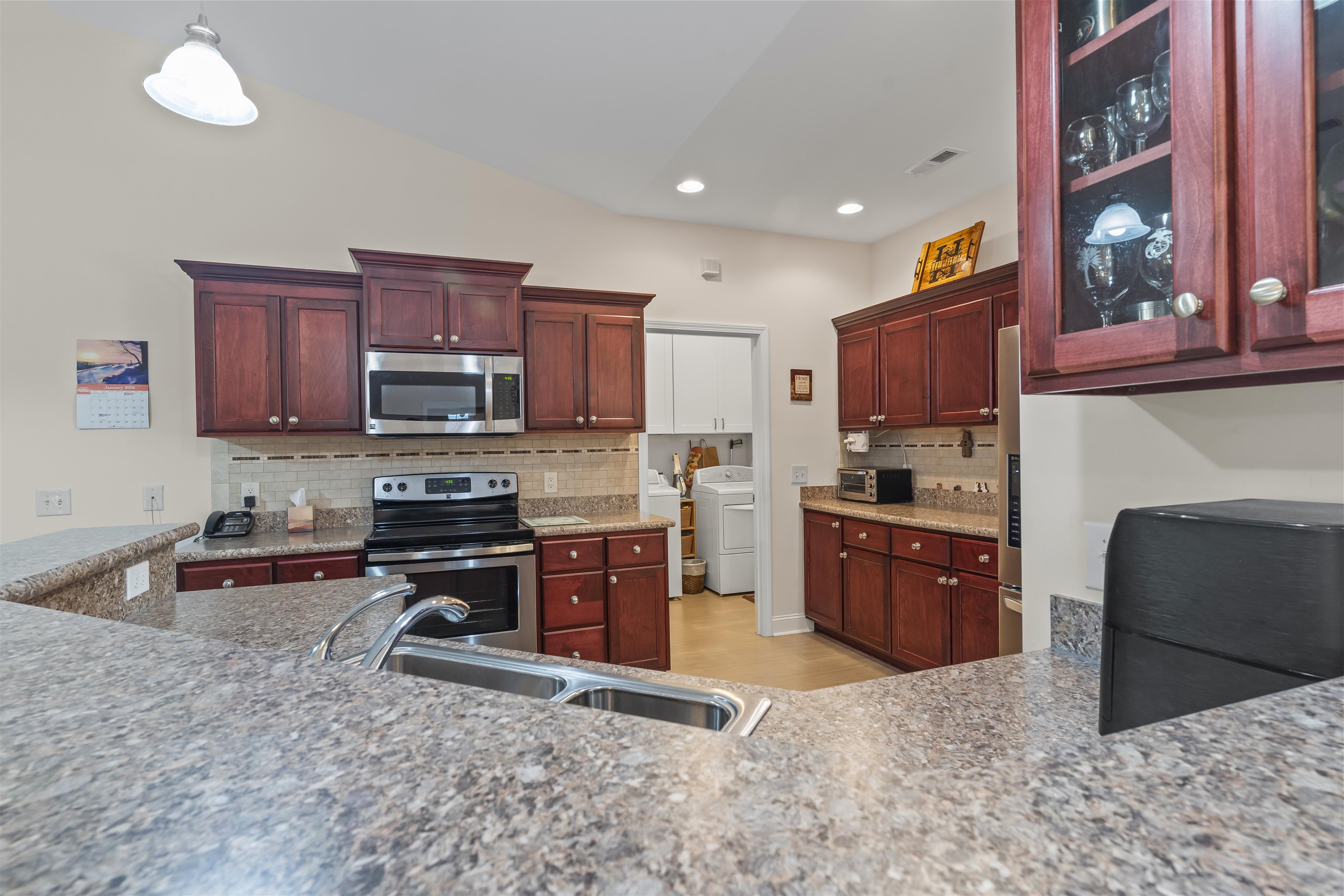 830 Payne Court Conway, SC 29526 - Photo 10 of 38 Kitchen with appliances with stainless steel finishes, light stone countertops, washer / dryer, dark brown cabinets, and recessed lighting