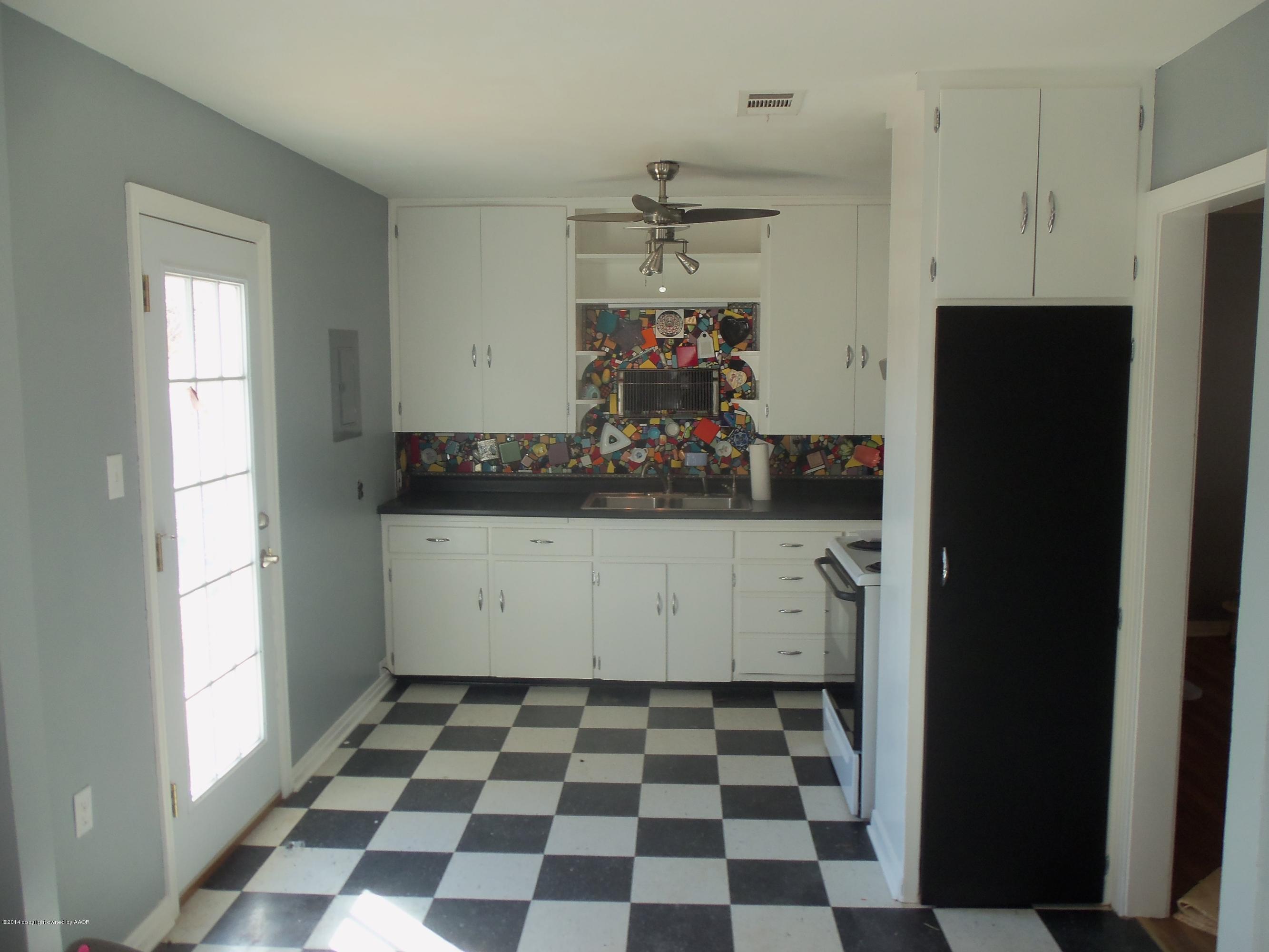4307 Parker Street Amarillo, TX 79110 - Photo 3 of 16 a kitchen with a checkered and a refrigerator