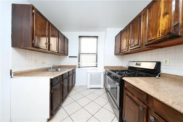 a kitchen with granite countertop a sink stove top oven and cabinets