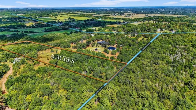 an aerial view of residential houses with outdoor space and trees
