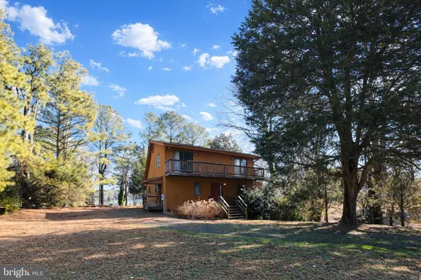 a view of a house next to a yard with large trees