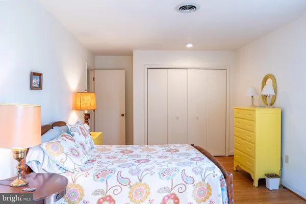 a bedroom with a bed and teddy bear on the dresser