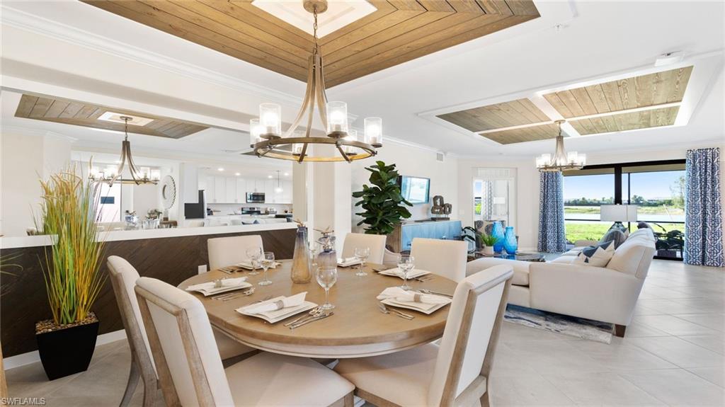 15170 Bluffton Lane, Unit 1811 Babcock Ranch, FL 33982 - Photo 17 of 20 a view of a dining room with furniture a chandelier and large windows