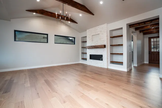 a view of empty room with wooden floor and fireplace