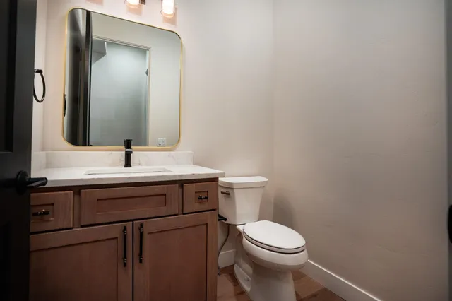 a bathroom with a toilet a sink and mirror