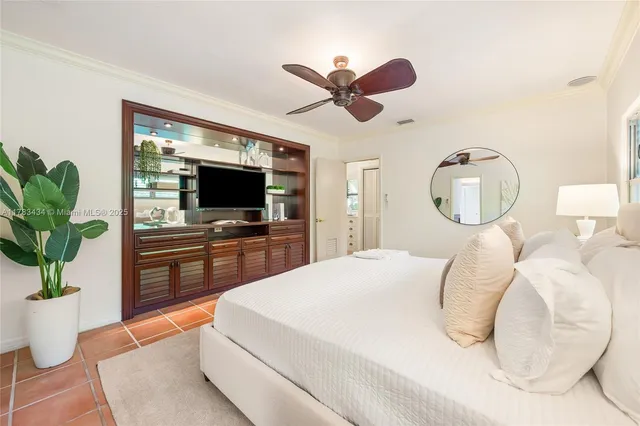 a bedroom with a large bed and a chandelier