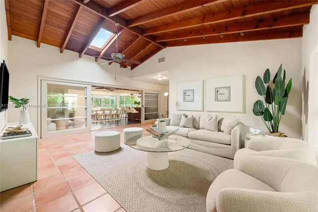 a living room with patio furniture and a potted plant