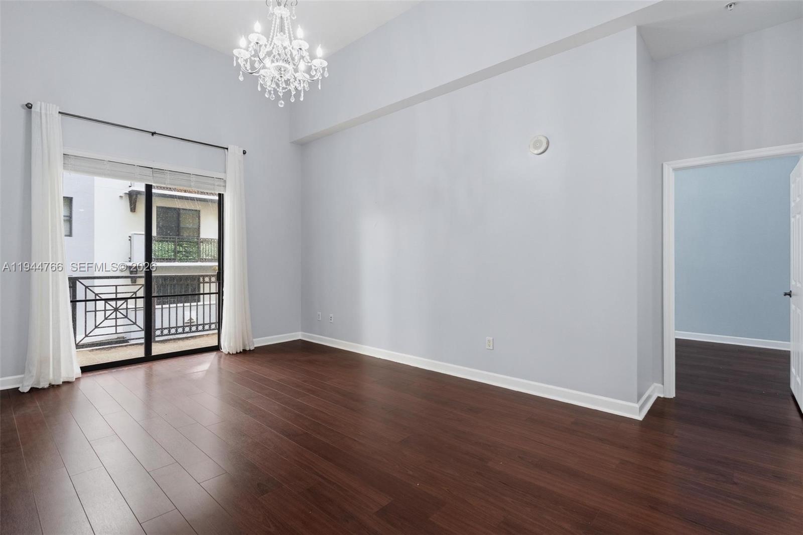 8395 Southwest 73rd Avenue, Unit 314 Miami, FL 33143 - Photo 12 of 49 a view of an empty room with wooden floor and a window