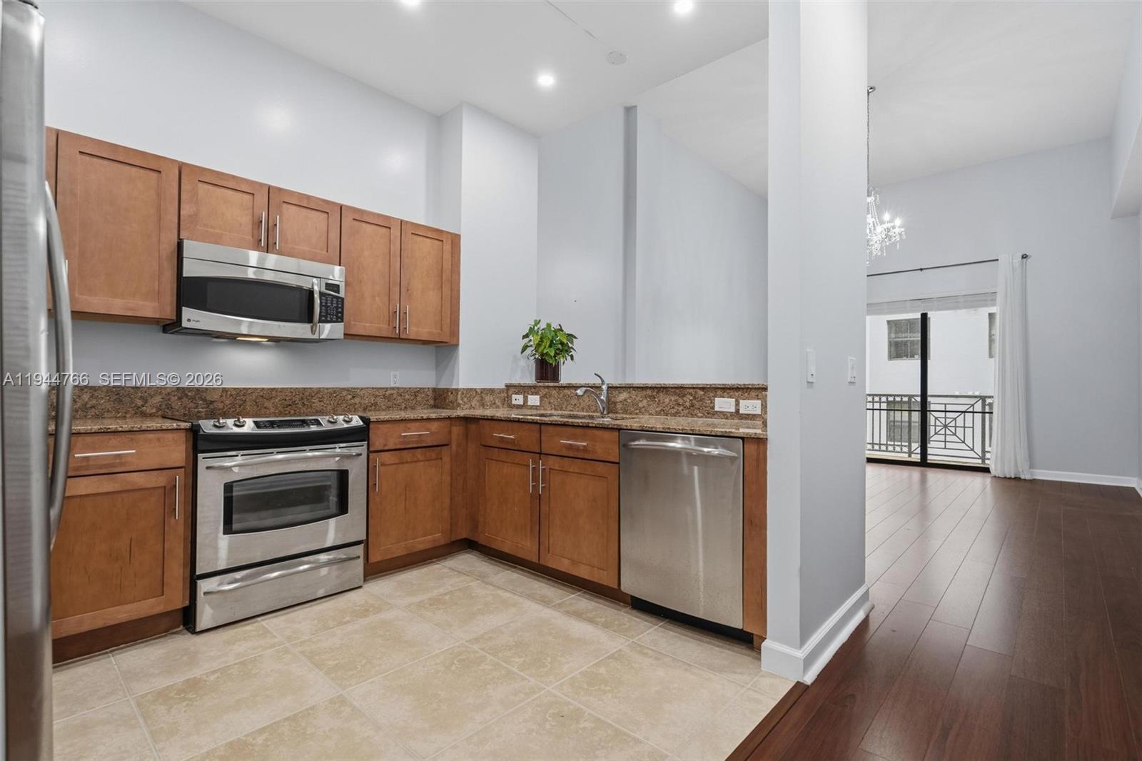 8395 Southwest 73rd Avenue, Unit 314 Miami, FL 33143 - Photo 19 of 49 a kitchen with stainless steel appliances granite countertop a stove a sink and a microwave