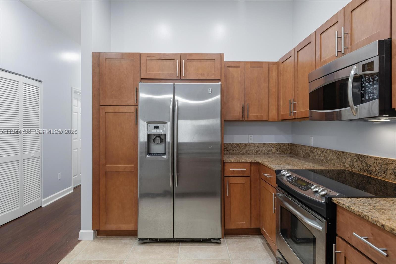 8395 Southwest 73rd Avenue, Unit 314 Miami, FL 33143 - Photo 22 of 49 a kitchen with stainless steel appliances granite countertop a refrigerator and a stove top oven