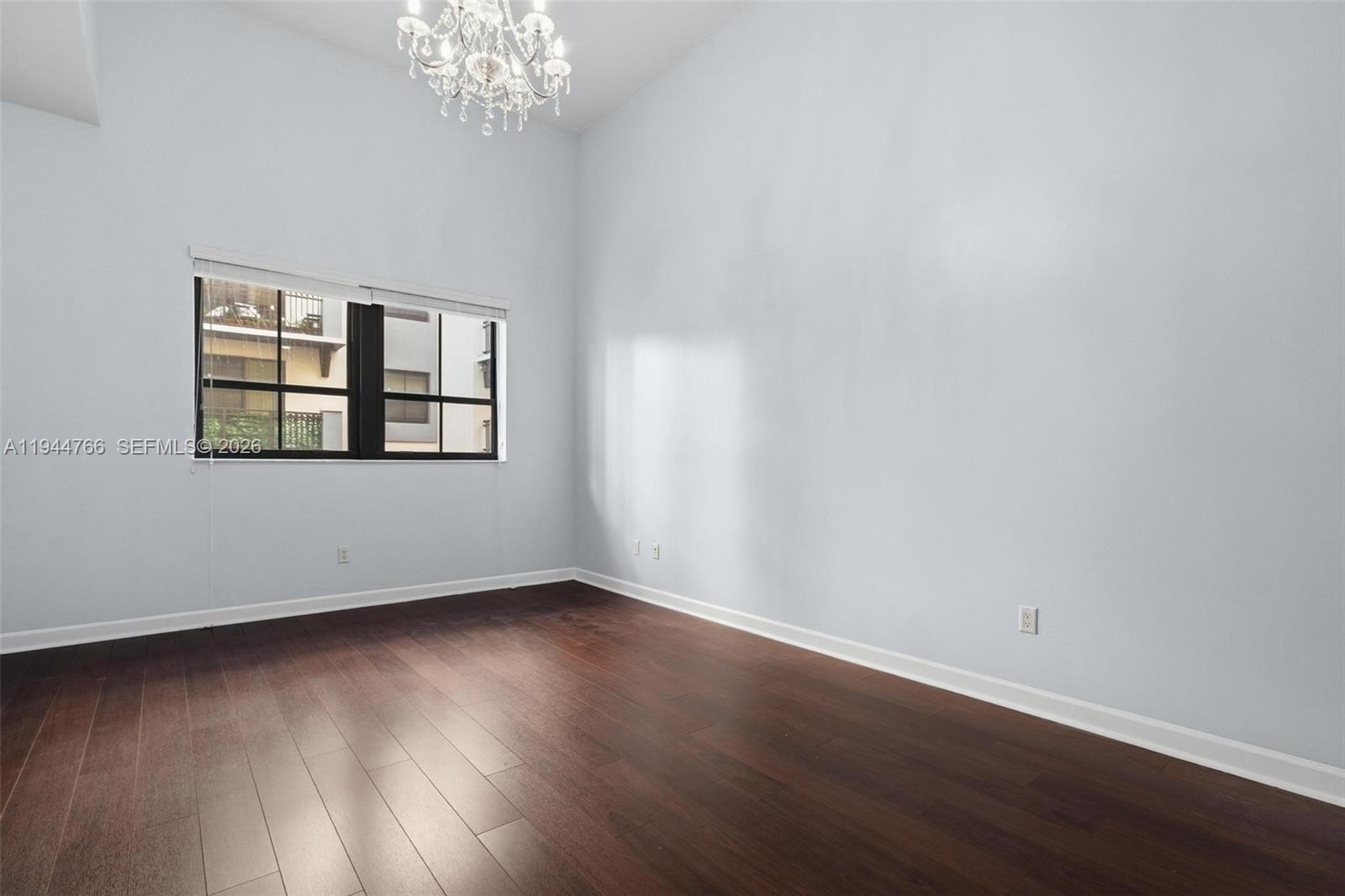 8395 Southwest 73rd Avenue, Unit 314 Miami, FL 33143 - Photo 32 of 49 a view of an empty room with wooden floor and a window