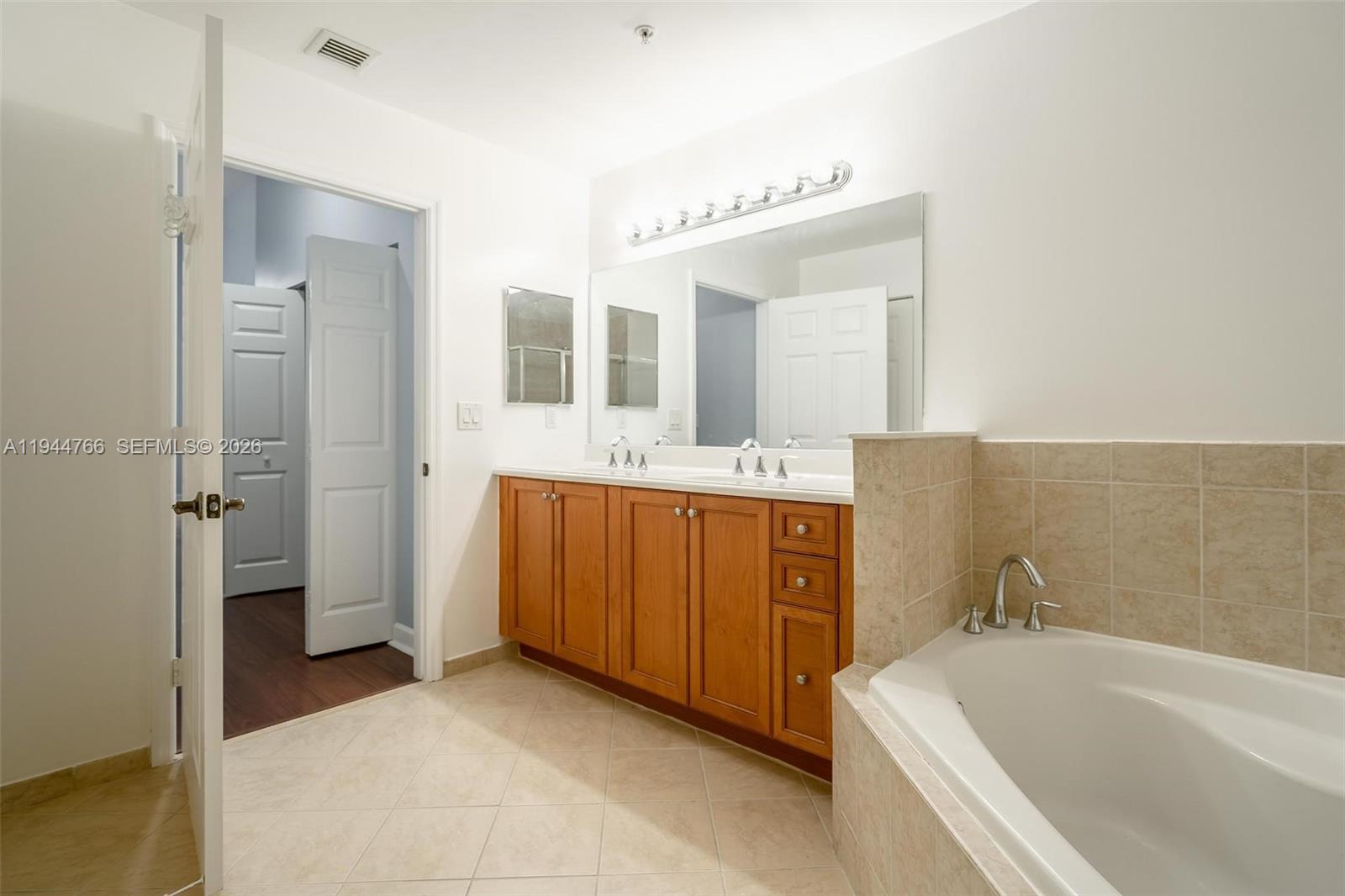 8395 Southwest 73rd Avenue, Unit 314 Miami, FL 33143 - Photo 39 of 49 a bathroom with a tub sink and mirror