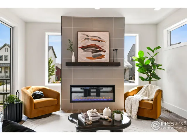 a living room with furniture a fireplace and a potted plant