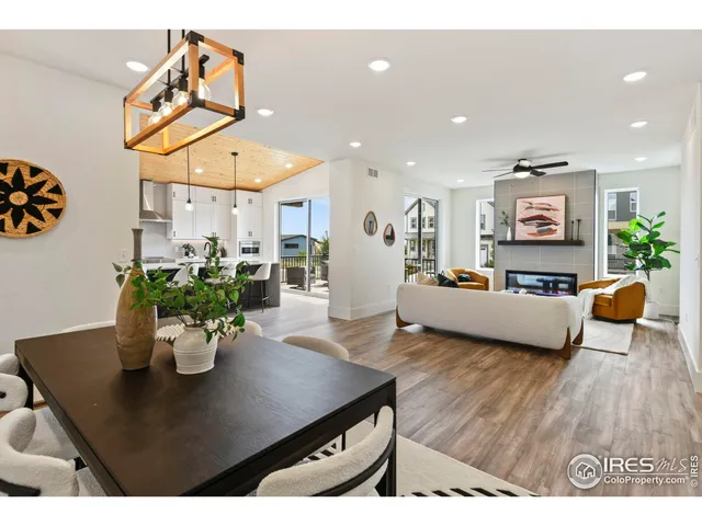 a living room with furniture kitchen view and a potted plant