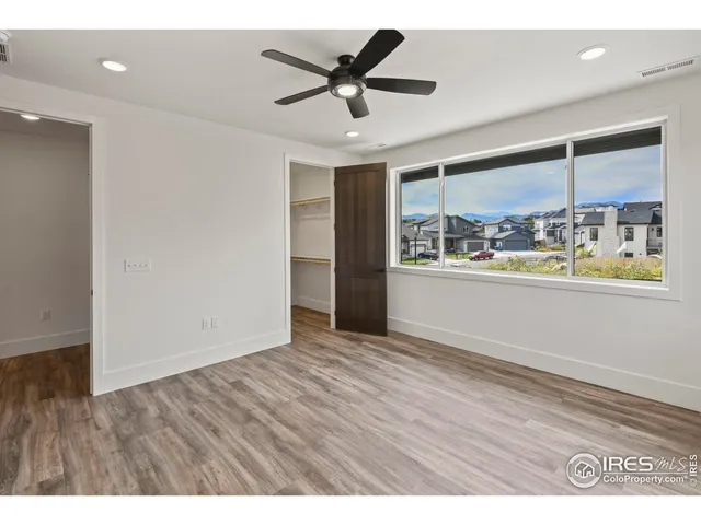 a view of an empty room with window and wooden floor
