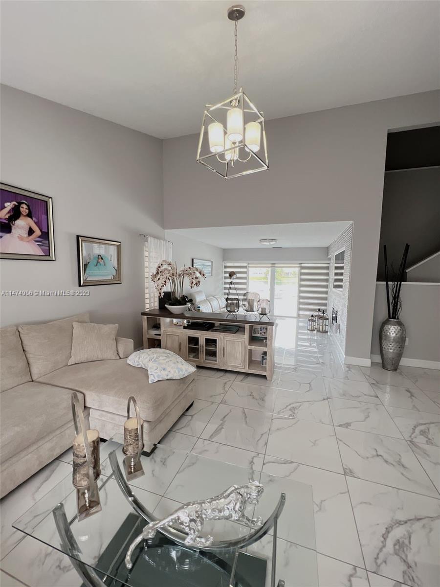 9357 Southwest 145th Place Miami, FL 33186 - Photo 11 of 15 a living room with furniture a flat screen tv and kitchen view