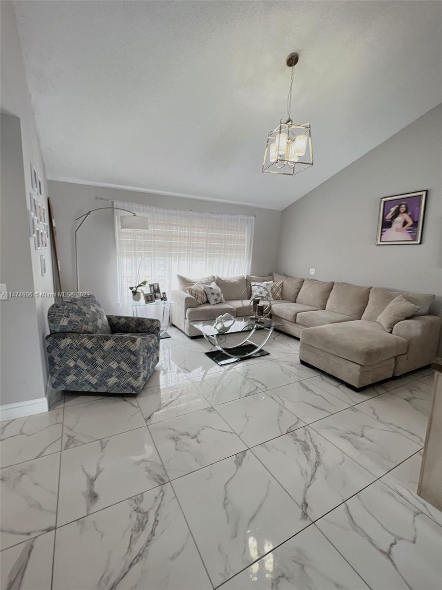 9357 Southwest 145th Place Miami, FL 33186 - Photo 12 of 15 a living room with furniture and a chandelier
