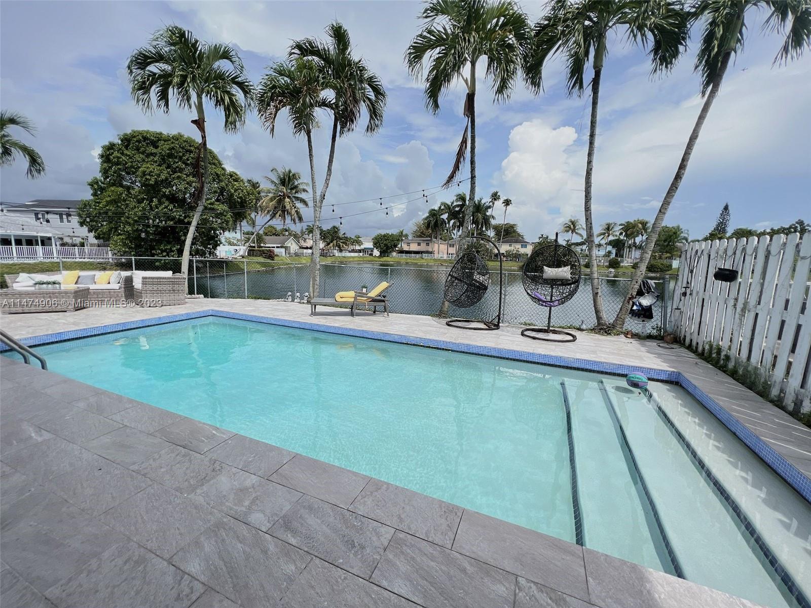 9357 Southwest 145th Place Miami, FL 33186 - Photo 13 of 15 a view of a swimming pool with a table and chairs