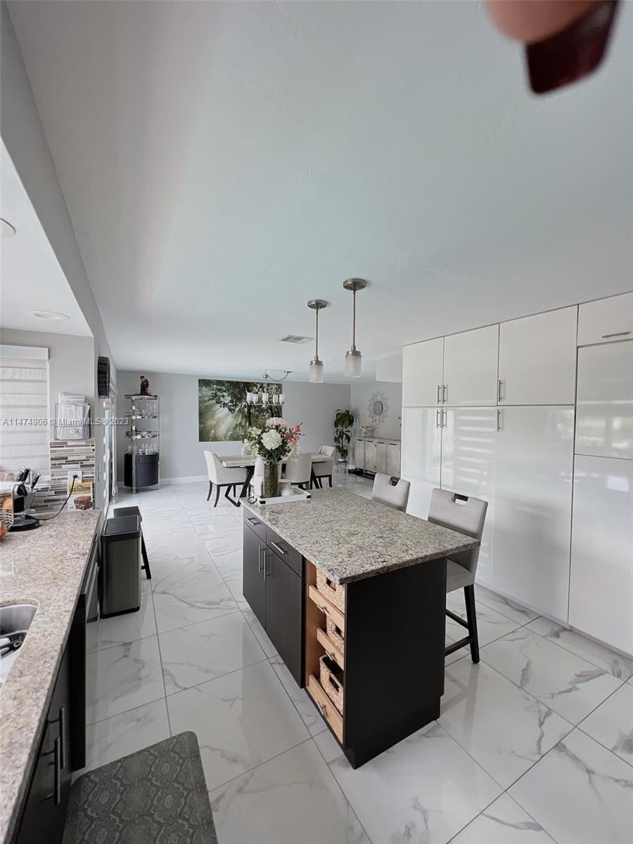 9357 Southwest 145th Place Miami, FL 33186 - Photo 4 of 15 a large kitchen with kitchen island a counter top a stove a sink dishwasher and a refrigerator