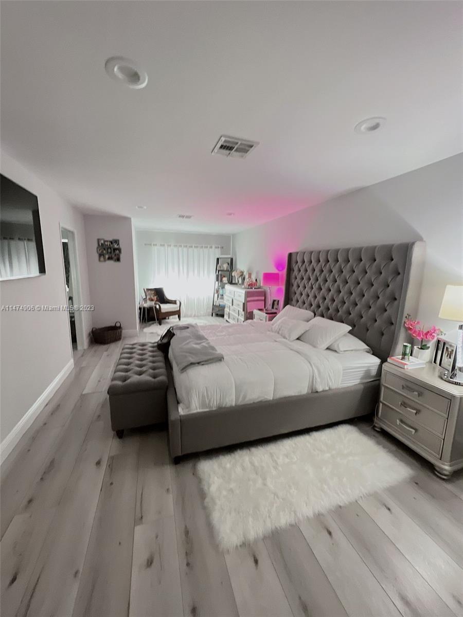 9357 Southwest 145th Place Miami, FL 33186 - Photo 8 of 15 a bedroom with a bed and wooden floor