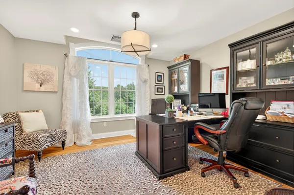 a view of a workspace with furniture and a window