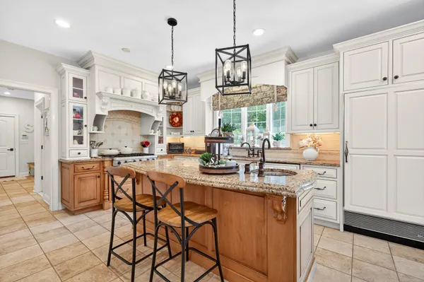a kitchen with stainless steel appliances granite countertop a sink and a refrigerator