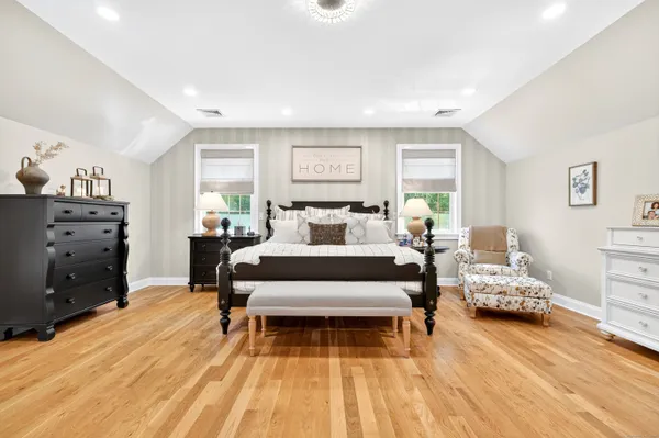 a bedroom with a bed and wooden floor