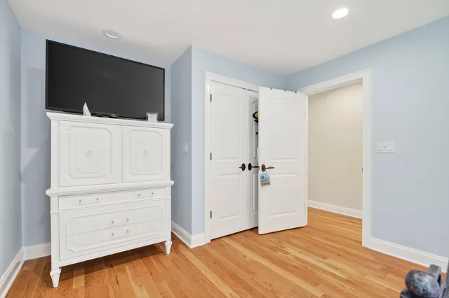 a view of an empty room with wooden floor and cabinet