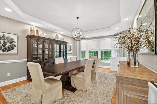 a dining room with furniture a chandelier and wooden floor