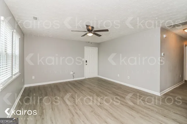 an empty room with windows and fan