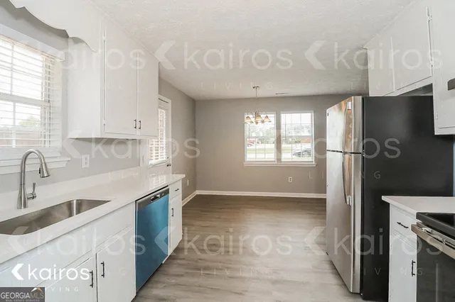 a kitchen with stainless steel appliances granite countertop a sink a stove and a refrigerator