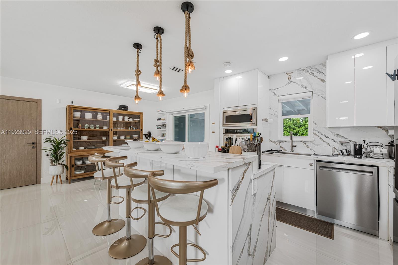 7235 Southwest 39th Street Miami, FL 33155 - Photo 14 of 30 a kitchen with stainless steel appliances kitchen island granite countertop a sink and cabinets