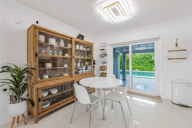 a large white kitchen with lots of counter space and furniture