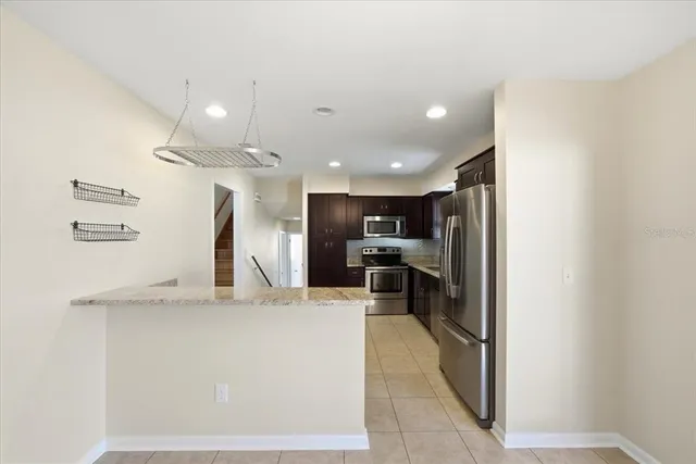 a view of kitchen with refrigerator and chairs