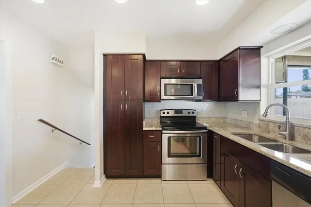 a kitchen with stainless steel appliances granite countertop a refrigerator stove a sink and dishwasher
