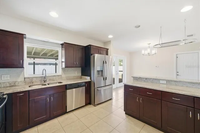 a kitchen with stainless steel appliances granite countertop a refrigerator and a sink
