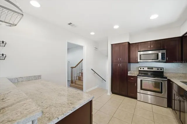 a kitchen with stainless steel appliances granite countertop a refrigerator and a stove top oven