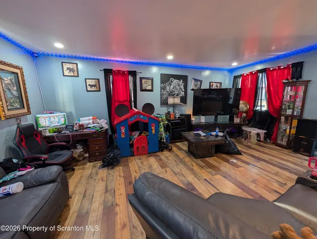 a living room with furniture a flat screen tv and a window