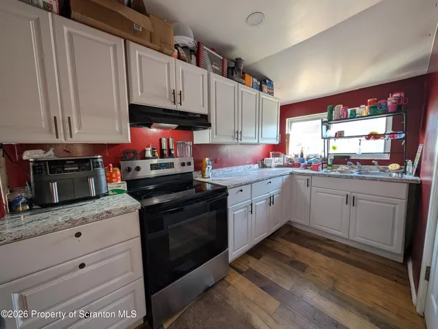a kitchen with granite countertop a sink stainless steel appliances and cabinets