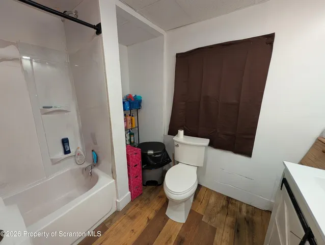 a white toilet sitting next to a bathroom sink and a bathtub