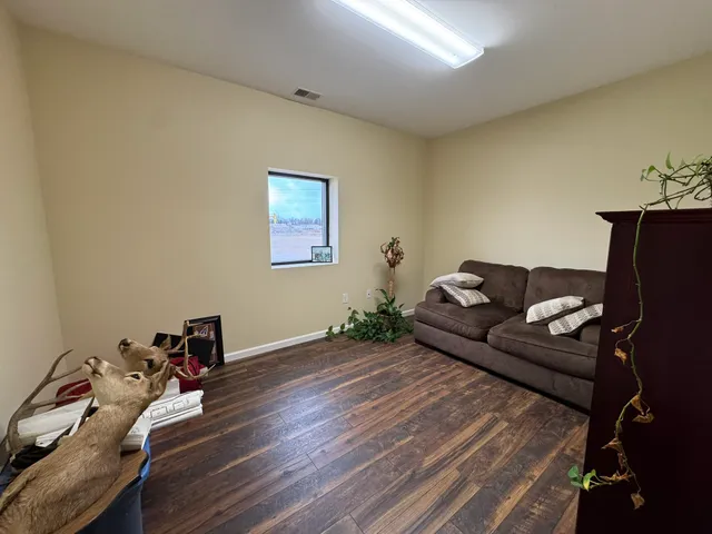 a view of a dining room and livingroom with furniture wooden floor a rug and a chandelier