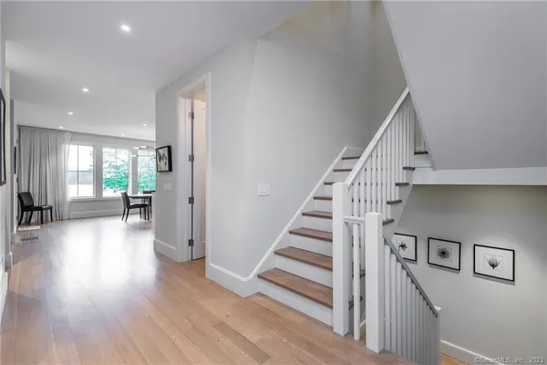 a view of a hallway with wooden floor and furniture