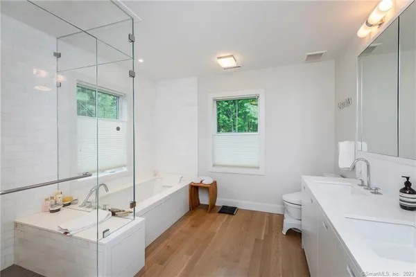 a bathroom with a tub sink and mirror