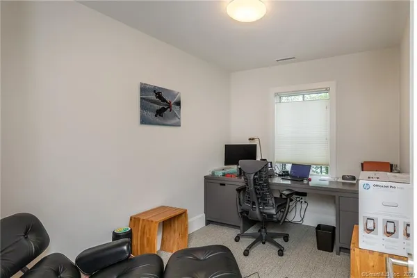 a view of a workspace with furniture and a window