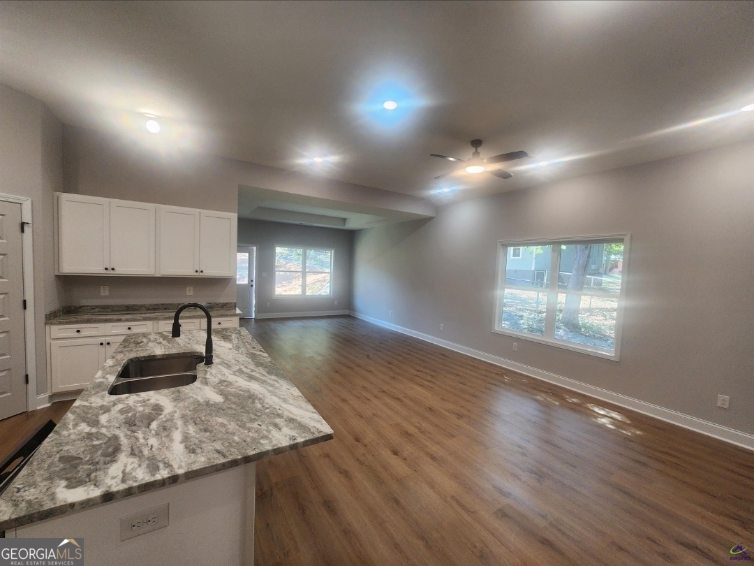 102 Silver Maple Court Byron, GA 31008 - Photo 3 of 17 a kitchen with kitchen island granite countertop a stove and a wooden floors