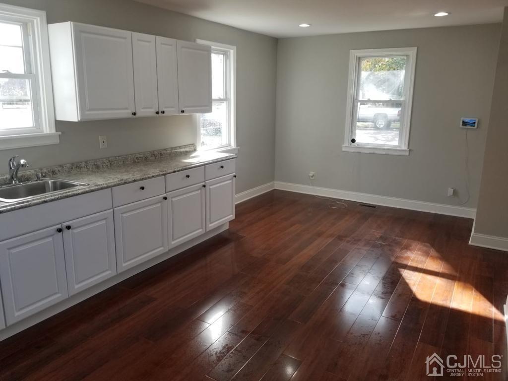 509 Heulings Avenue Riverside, NJ 08075 - Photo 8 of 38 a kitchen with granite countertop white cabinets a sink and dishwasher with wooden floor