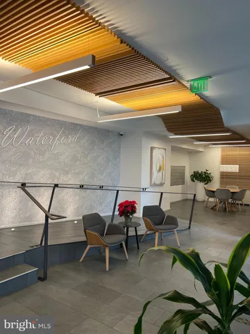 a patio with table and chairs and potted plants