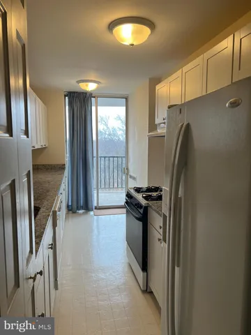 a kitchen with granite countertop a refrigerator and a stove
